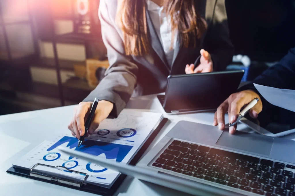 Profesional trabajando con gráficos y computadora para desarrollar una estrategia de marketing desde cero