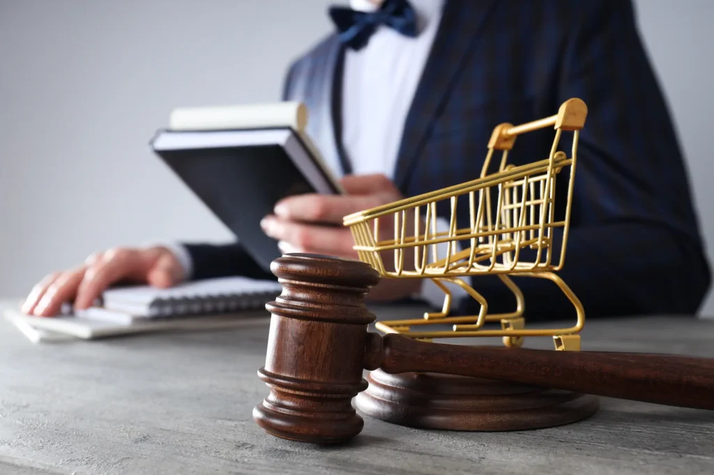 Concepto de comercio electrónico con carrito de compras y mazo judicial, relacionado con protección de marca en negocios digitales