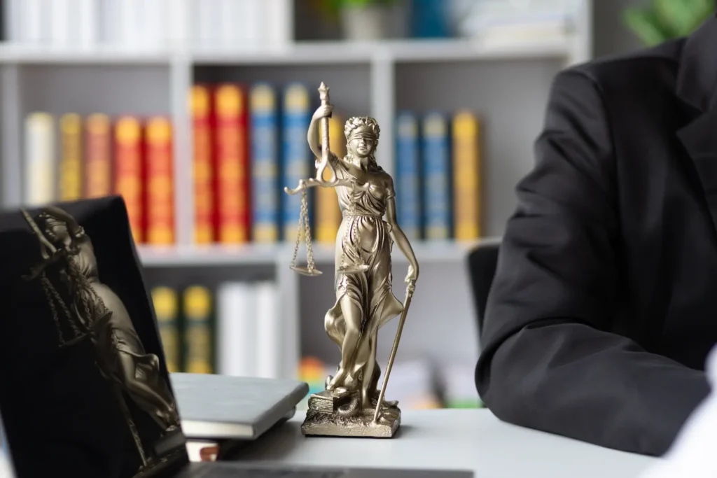 Estatua de la justicia en despacho legal con biblioteca jurídica, representando asesoría para registrar y proteger una marca en México