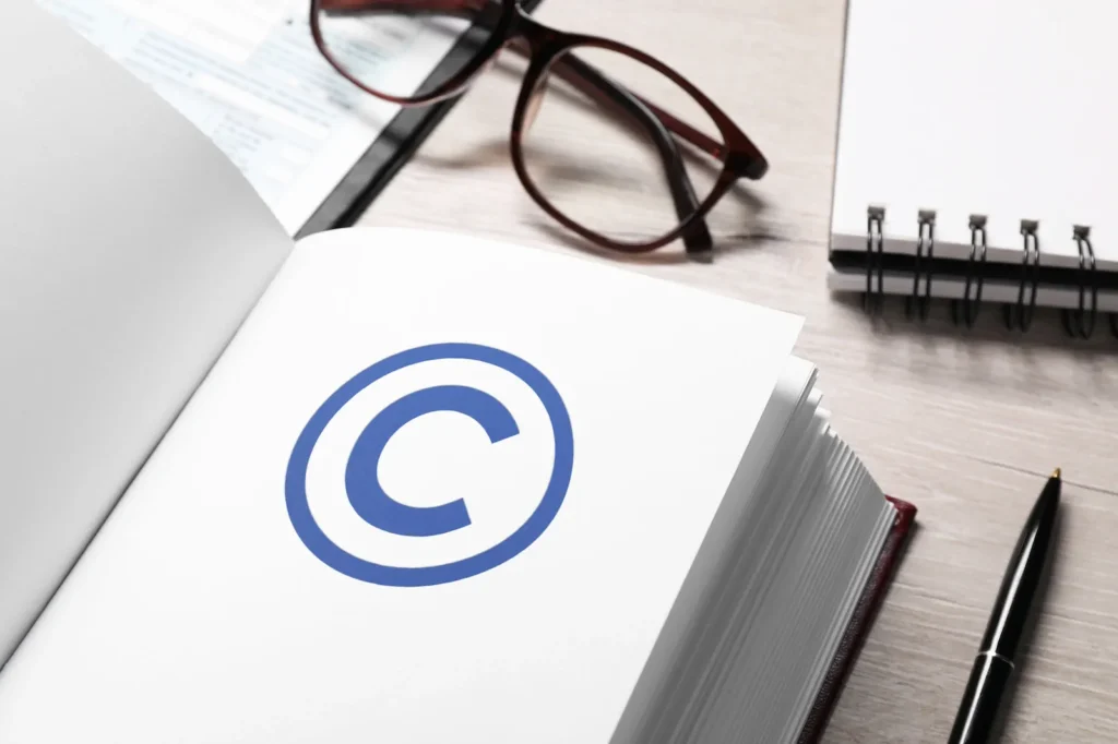 Símbolo de copyright en documentos legales junto a lentes, relacionado con la protección de propiedad intelectual y marcas