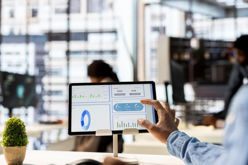 Empresario revisando reportes financieros y gráficos de rendimiento en un sistema ERP empresarial