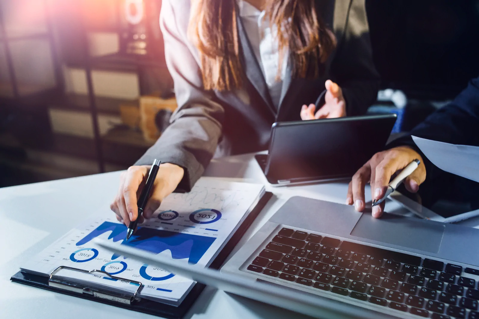 Profesional trabajando con gráficos y computadora para desarrollar una estrategia de marketing desde cero